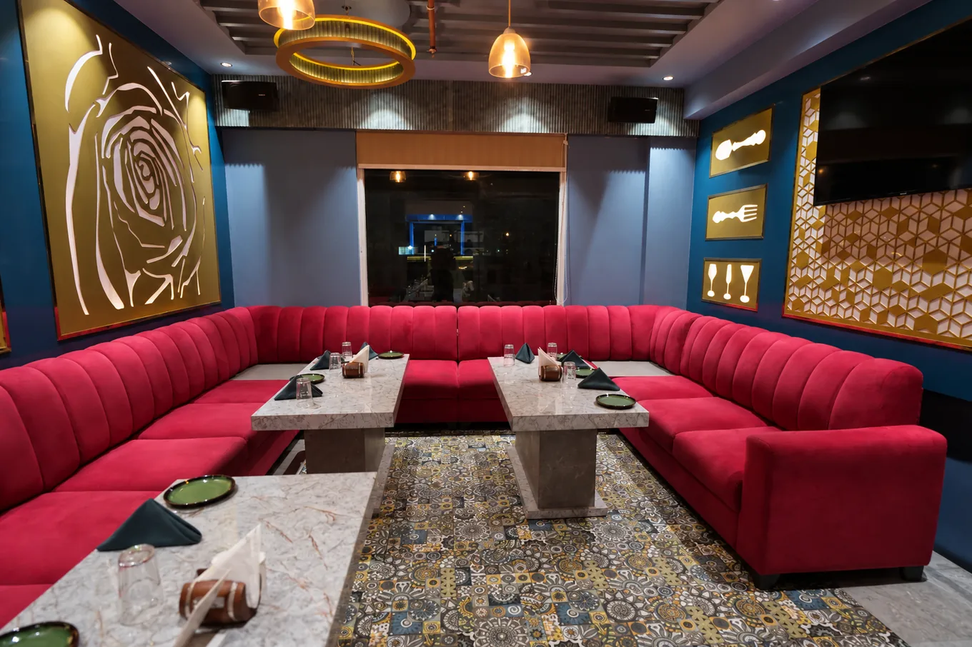 Red wraparound sofa and marble dining tables in a blue lounge